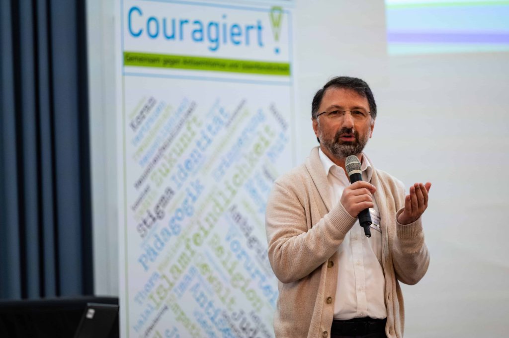 Mustafa Cimşit – stehend während Vortrag